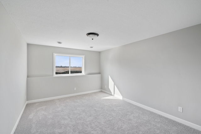 carpeted spare room with a textured ceiling