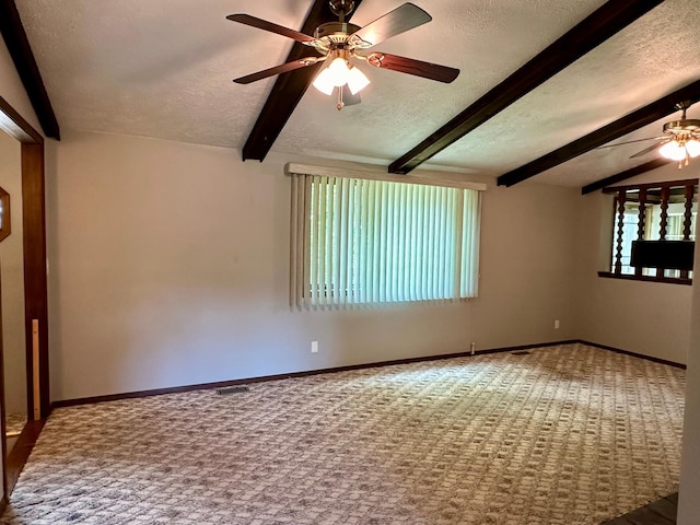 carpeted spare room featuring a textured ceiling, lofted ceiling with beams, and ceiling fan