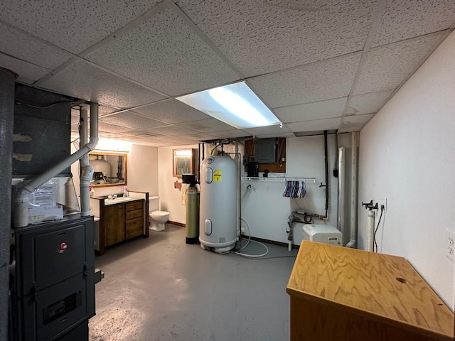 basement with water heater, electric panel, and a paneled ceiling