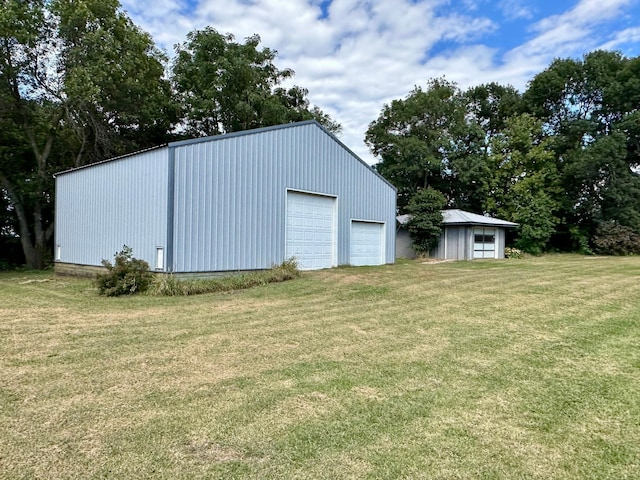 view of outdoor structure featuring a lawn and a garage