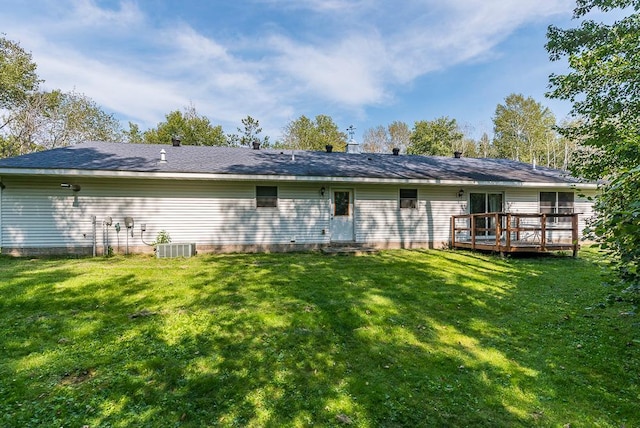 back of house featuring a lawn, a wooden deck, and central AC