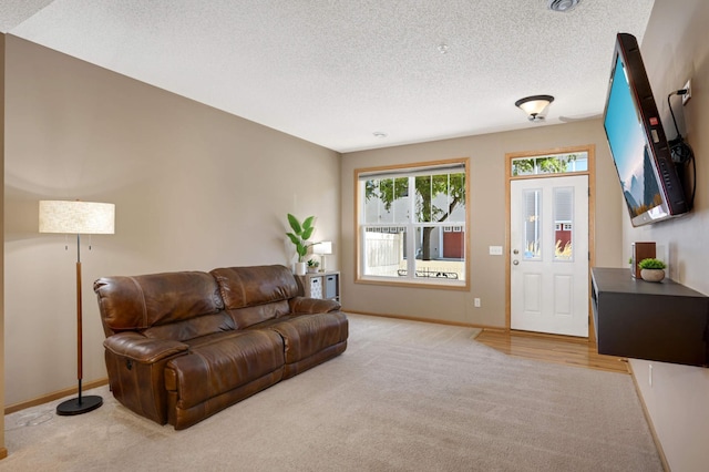 carpeted living room featuring a textured ceiling