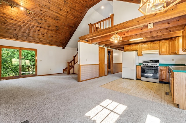 kitchen featuring white appliances, high vaulted ceiling, decorative light fixtures, and light colored carpet