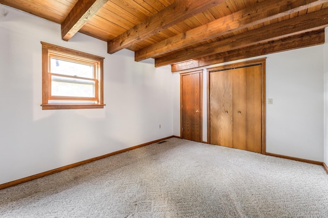 unfurnished bedroom with wooden ceiling, carpet floors, and beamed ceiling