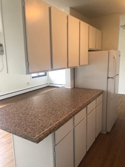 kitchen featuring dark hardwood / wood-style flooring and white fridge