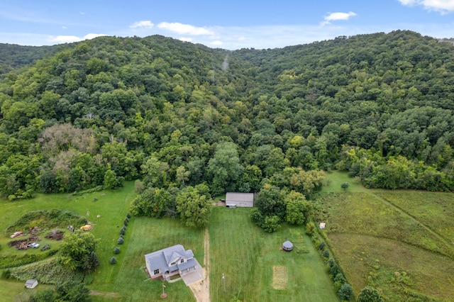 birds eye view of property with a mountain view and a wooded view