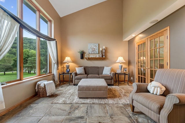 living area featuring baseboards and high vaulted ceiling