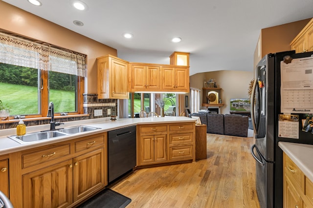 kitchen with freestanding refrigerator, a sink, light countertops, dishwasher, and open floor plan