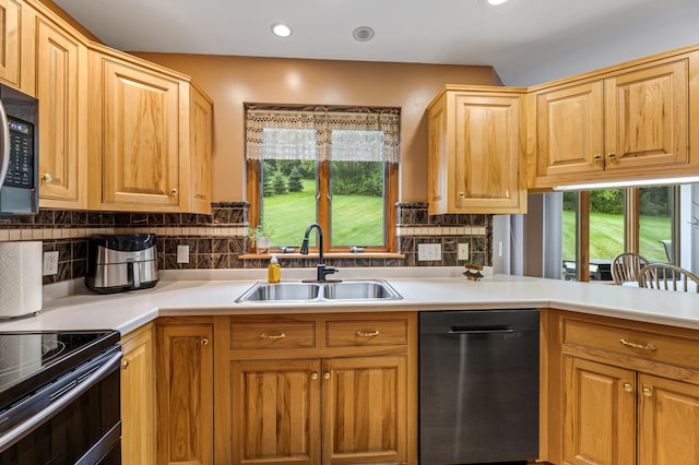 kitchen with a sink, dishwashing machine, tasteful backsplash, and light countertops