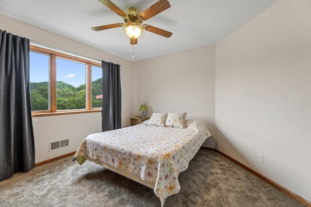 carpeted bedroom with a ceiling fan, baseboards, and visible vents