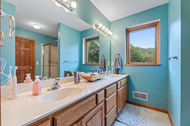 bathroom featuring visible vents, a stall shower, baseboards, and a sink