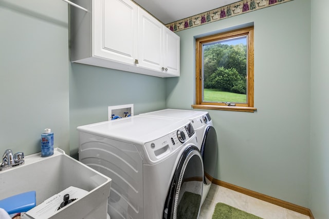 laundry room featuring baseboards, light tile patterned flooring, cabinet space, a sink, and washing machine and dryer