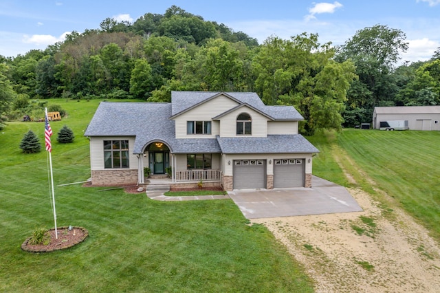 view of front facade with a front lawn, driveway, covered porch, roof with shingles, and an attached garage