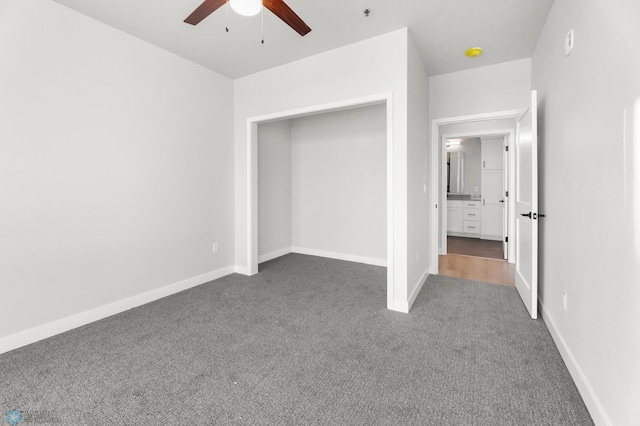 unfurnished bedroom featuring a closet, ceiling fan, and dark colored carpet