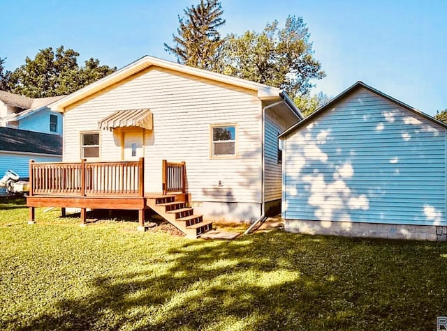 rear view of property featuring a wooden deck and a lawn