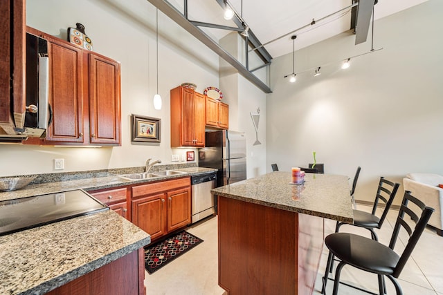 kitchen with a kitchen island, appliances with stainless steel finishes, a breakfast bar, pendant lighting, and sink