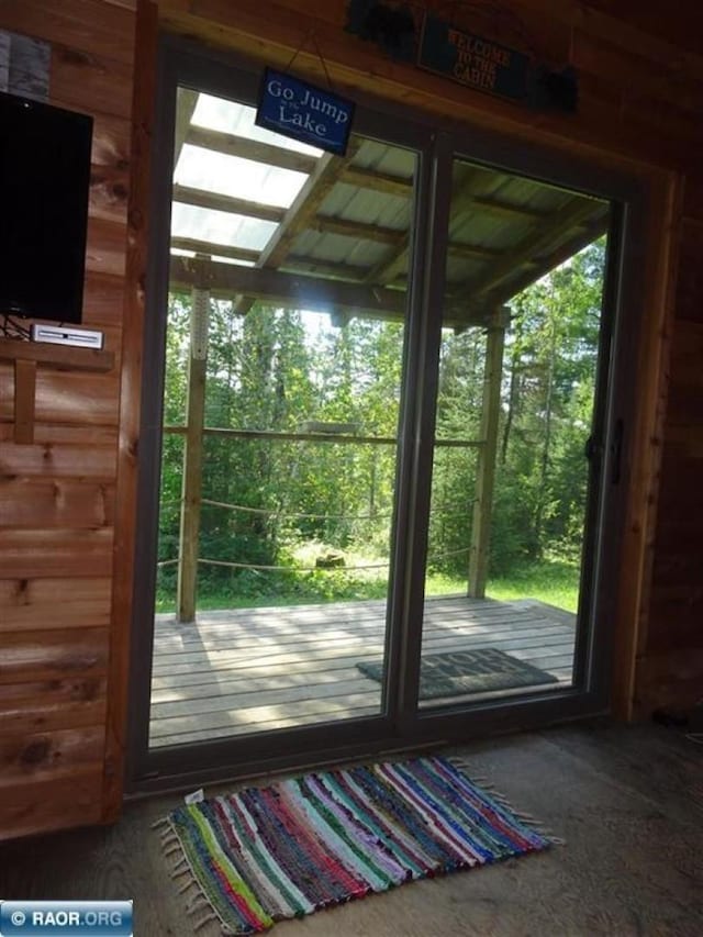 doorway featuring wooden walls and a healthy amount of sunlight