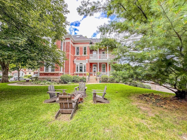 exterior space featuring covered porch, a balcony, and an outdoor fire pit