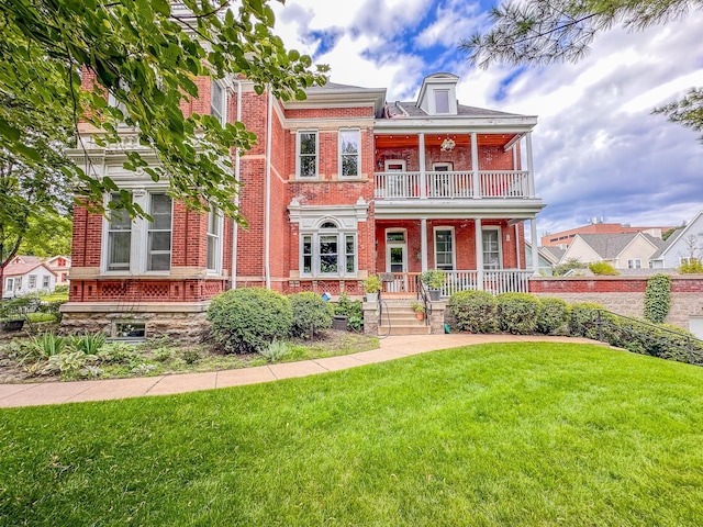 view of front of property featuring a balcony, covered porch, and a front yard