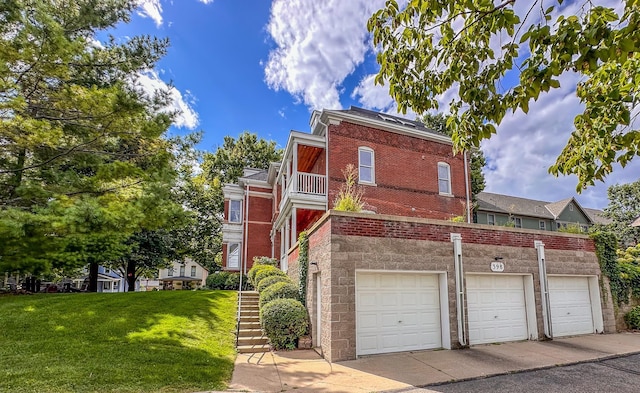 view of front facade with a front yard, a balcony, and a garage