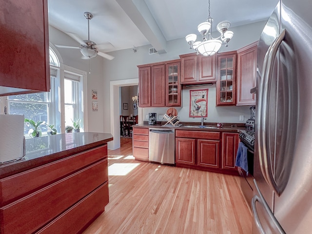 kitchen featuring ceiling fan with notable chandelier, beam ceiling, light wood-type flooring, and appliances with stainless steel finishes