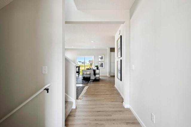 corridor with a textured ceiling and light hardwood / wood-style flooring