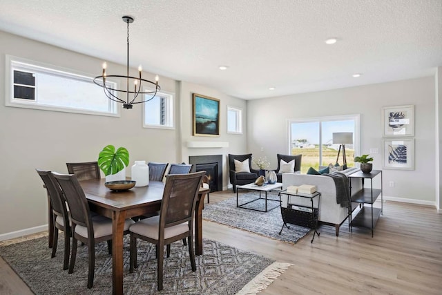 dining area featuring plenty of natural light, a textured ceiling, and wood-type flooring