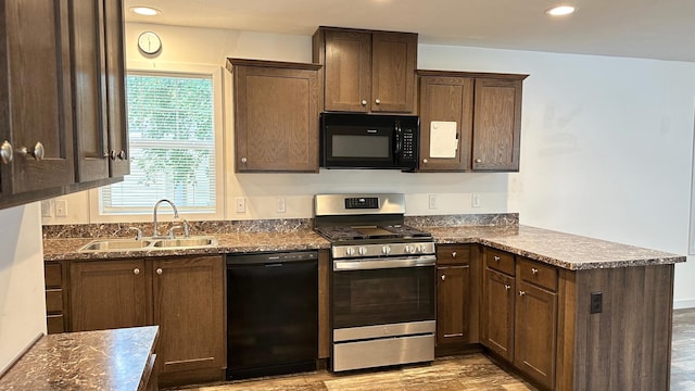 kitchen with dark stone counters, light wood-type flooring, dark brown cabinets, sink, and black appliances