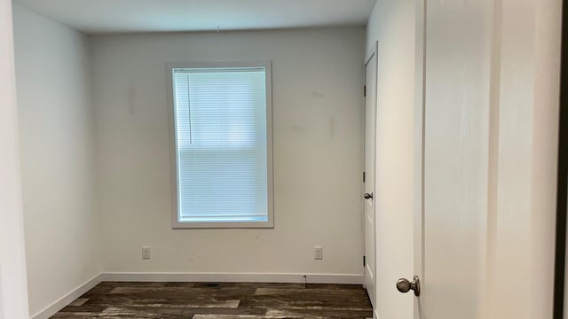 unfurnished room with dark wood-type flooring