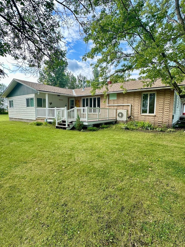 back of house featuring a wooden deck and a lawn