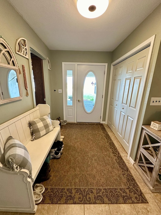 tiled foyer entrance featuring a textured ceiling