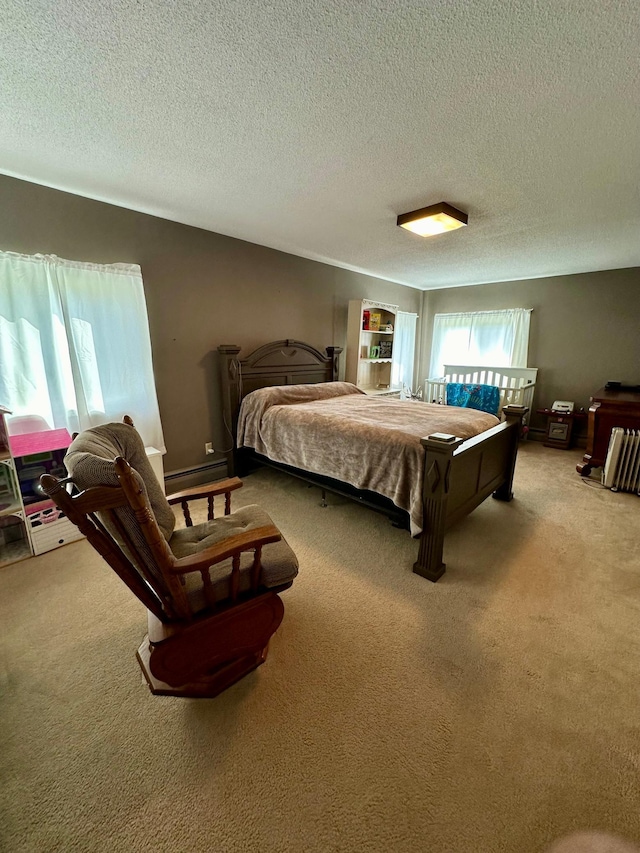 carpeted bedroom featuring a textured ceiling and a baseboard heating unit