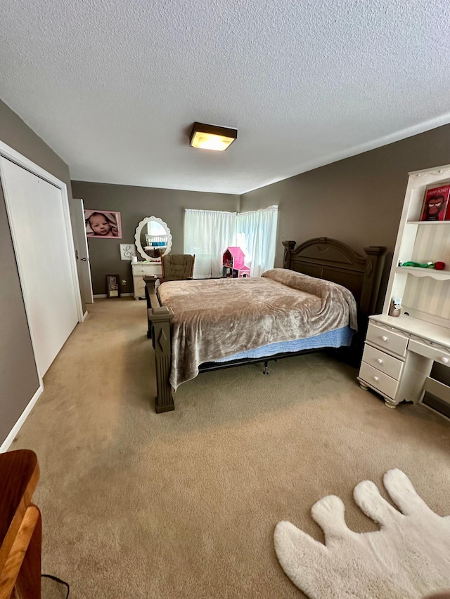 bedroom featuring a closet, light colored carpet, and a textured ceiling