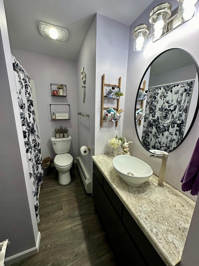 bathroom with toilet, a baseboard radiator, vanity, and wood-type flooring