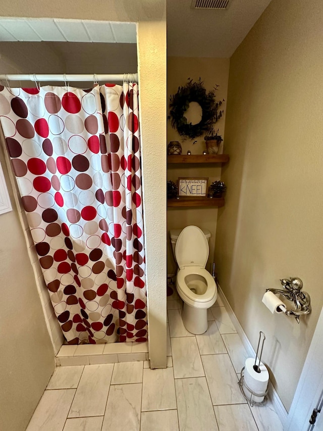 bathroom with toilet, tile patterned flooring, and a shower with curtain