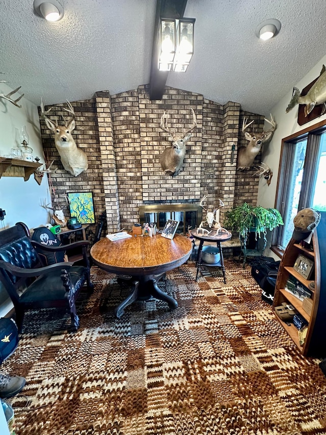 dining room featuring a textured ceiling and brick wall