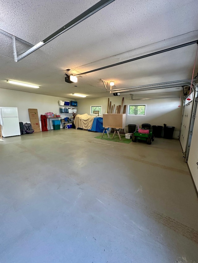 garage featuring a garage door opener and white refrigerator