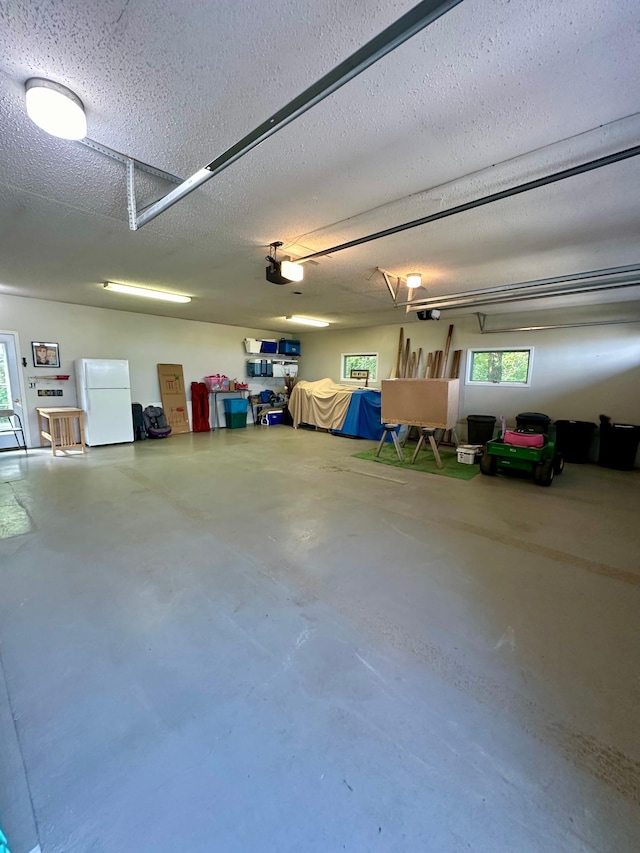 garage featuring a garage door opener and white fridge