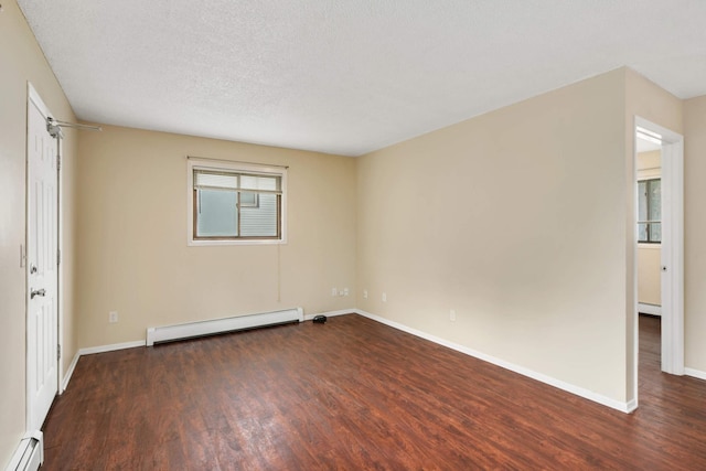 unfurnished room with a textured ceiling, a baseboard heating unit, and dark hardwood / wood-style flooring