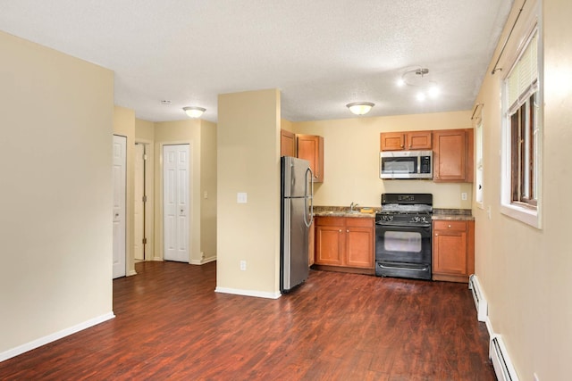 kitchen featuring a baseboard radiator, a textured ceiling, stainless steel appliances, dark wood-type flooring, and sink