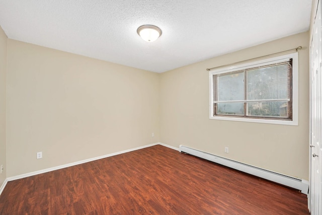 spare room featuring a textured ceiling, dark wood-type flooring, and a baseboard radiator