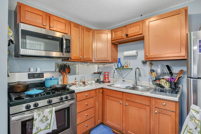 kitchen featuring appliances with stainless steel finishes, a textured ceiling, and sink