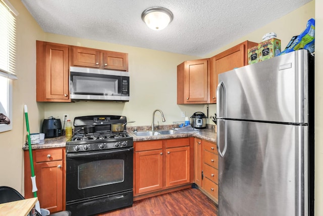 kitchen featuring a textured ceiling, stainless steel appliances, sink, and dark hardwood / wood-style flooring