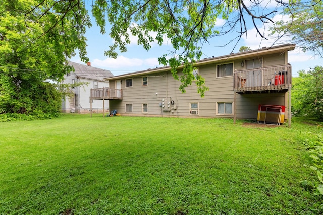 rear view of house featuring a balcony and a yard