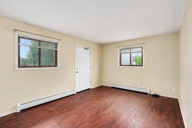 unfurnished room with a baseboard heating unit, plenty of natural light, and dark hardwood / wood-style floors