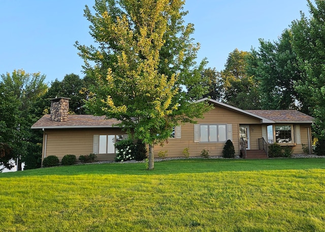 single story home featuring a chimney and a front yard