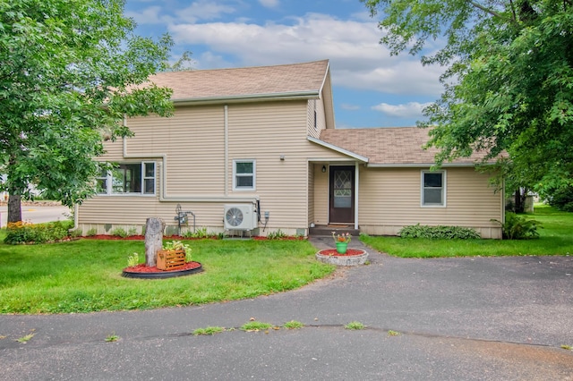 view of front of property with a front lawn and ac unit