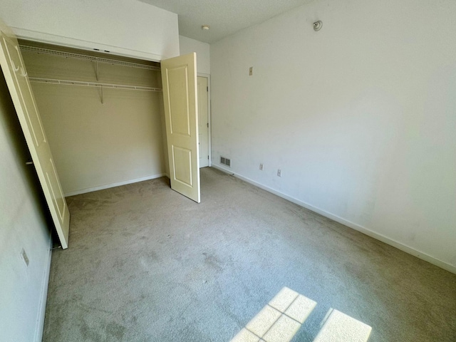 unfurnished bedroom featuring a closet, visible vents, carpet flooring, and baseboards