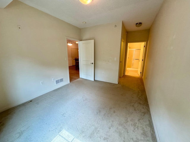 unfurnished bedroom featuring baseboards, visible vents, and carpet