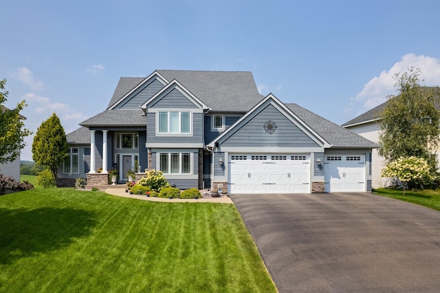 craftsman inspired home featuring a garage and a front lawn